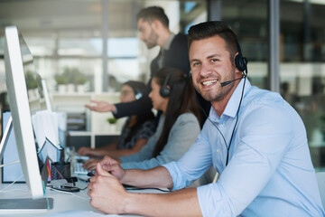Great service makes great business. Portrait of a happy and confident young man working in a call center.