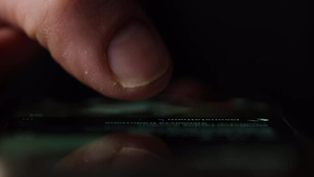 Macro shot of a finger doom scrolling social media or browsing internet. Front view with reflection on glass