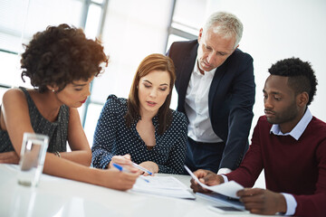 Strategizing their way to success. Cropped shot of corporate businesspeople in the boardroom.