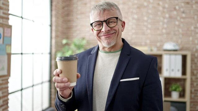 Middle age grey-haired man business worker smiling confident drinking coffee at office