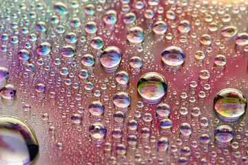 Water drops. Abstract background. Colored macro texture with many drops. Iridescent wet gradient. Heavily textured image. Shallow depth of field. Selective focus