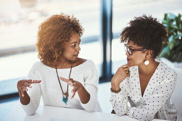 She has great ideas. Shot of two young designers working in an modern office.