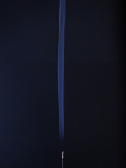 incense smoke creating linear shapes on a dark blue background