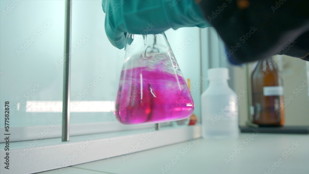 Poster close-up of flask with chemical liquid. clip. laboratory assistant conducts experiments with chemica