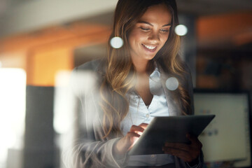 Working hard no matter the time. Shot of a young attractive businesswoman working late at night in...
