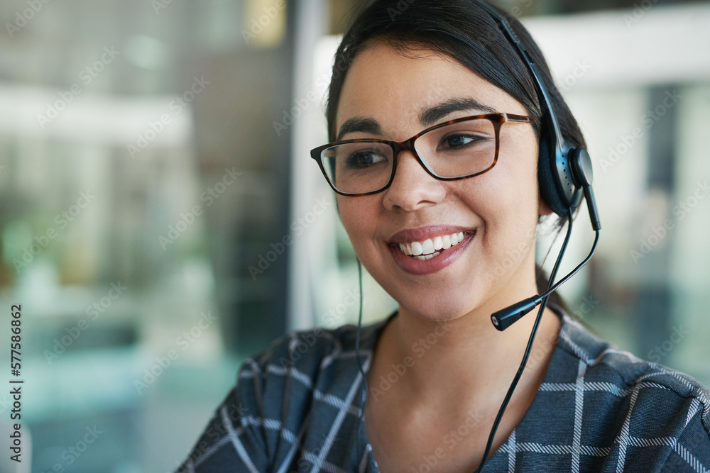 Poster Shes a delight to speak to. Shot of a happy young woman using a headset at work.