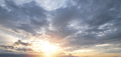 Naklejka na ściany i meble The light of the evening sun shines on the gray clouds.