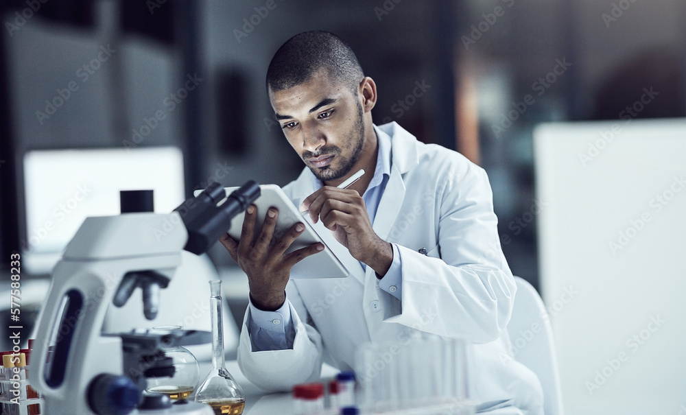 Poster organizing the test results. shot of a scientist recording his findings on a digital tablet.