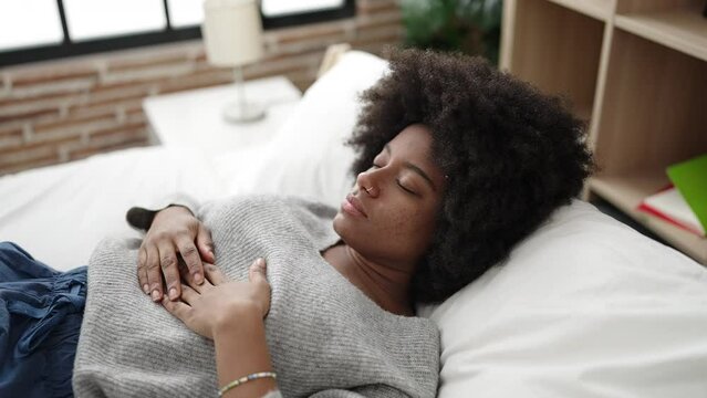 African american woman lying on bed sleeping at bedroom