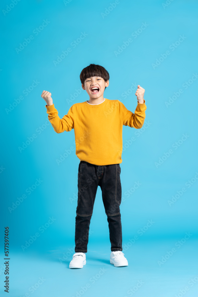 Wall mural full body image of asian boy posing on blue background