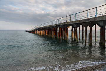 Old rusty pier in blue sea. Koktebel. Crimea