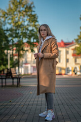 Fototapeta premium Portrait of a young beautiful fair-haired girl on a summer city street.