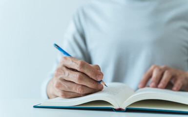 Adult writing and reading book. Student studying or learning with textbook at home. Success idea concept of education knowledge development and cognition learning .Business and education concept