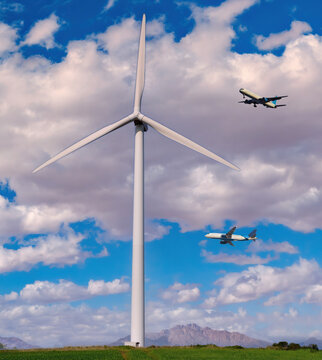 Wind electric power turbine and flying airplanes above. Conceptual image symbolizing climate changes of our planet due to the emissions of CO2.