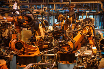 Modern robot welder processes metal part in factory workshop