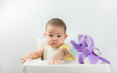 Cute Baby Boy Sitting In High Chair And Playing With His Toy