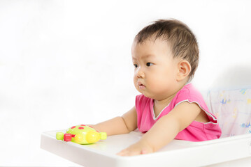 Cute Baby Boy Sitting In High Chair And Playing With His Toy