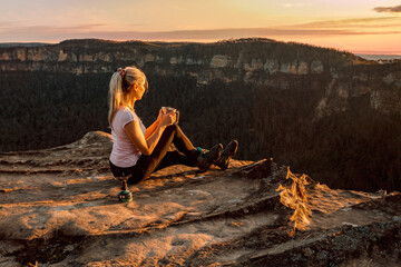 Girl is watching sunsets on cliff tops - 577606879