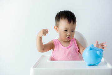 Asia baby boy saving money for future concept on white background, Happy baby with a piggy bank