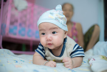Asian newborn baby playing at home
