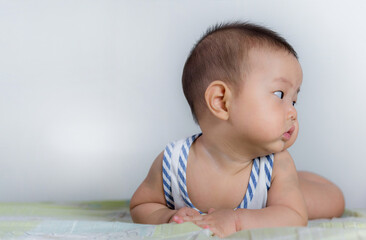 Asian newborn baby playing at home