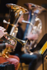 A musician playing a trumpet in a trumpet section of an orchestra during rehearsal - obrazy, fototapety, plakaty