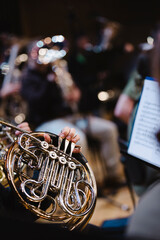 A musician playing a French horn during an orchestra rehearsal