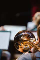 A musician playing a trombone during a casual wind ensemble rehearsal just before the concert