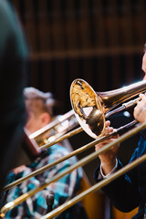 A musician playing a trombone during a casual wind ensemble rehearsal just before the concert