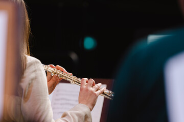 A musician playing the flute during in a wind band rehearsal