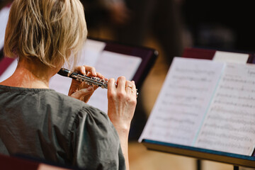 A musician playing the piccolo flute during in a wind band rehearsal