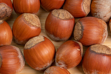 Hazelnuts in shells on wooden background close up. Whole and shelled organic hazelnuts on a wooden table. Nut in shell video concept