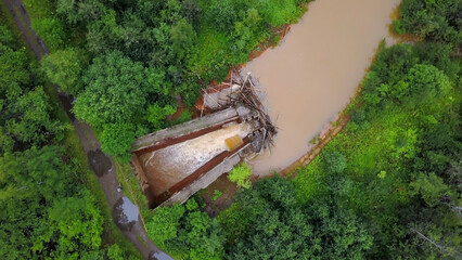 Aerial top view of a river and a dam of tree trunks. Clip. Dirty river and green trees. © Media Whale Stock