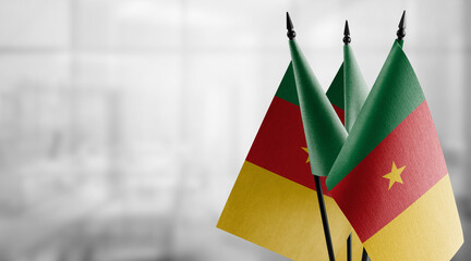 Small flags of the Cameroon on an abstract blurry background