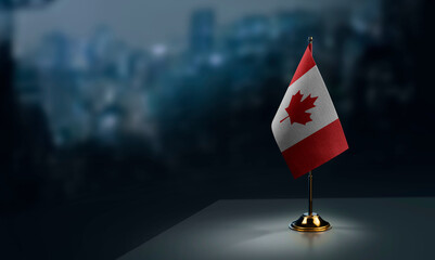 Small flags of the Canada on an abstract blurry background - obrazy, fototapety, plakaty