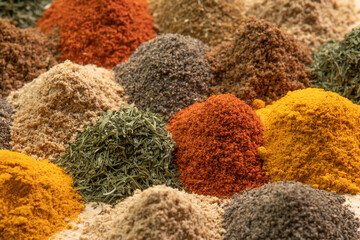 Spice and seasoning. Various fragrant spice market. Heap different Asian Spices lies on wooden background. Assortment spices and herbs for cooking