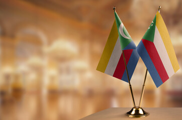 Small flags of the Comoros on an abstract blurry background