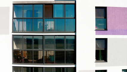 Fototapeta premium Flying close to the new multi storey building with balconies and big windows. Stock footage. Buildings of the city sleeping area.