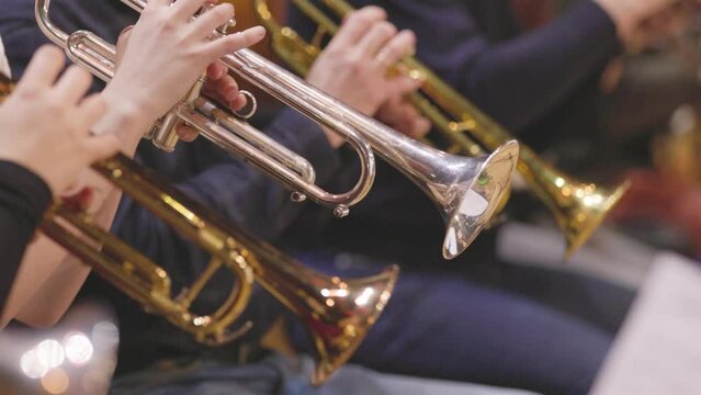 A trumpet section of an orchestra playing during a rehearsal