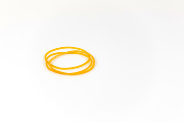 Yellow rubber bands are placed on a white background.