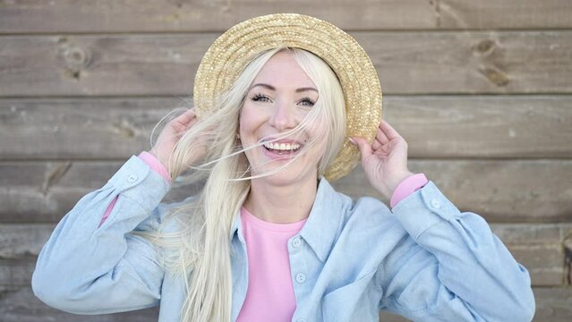 Young blonde woman tourist smiling confident wearing summer hat over isolated wooden background
