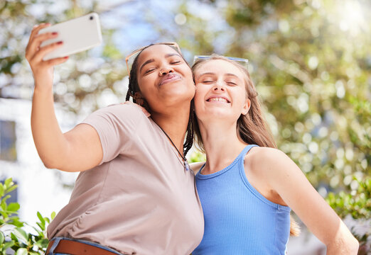 Selfie, friendship and women on an outdoor walk for wellness, health and exercise in the park. Love, smile and happy interracial female best friends taking a picture together in nature in a garden.