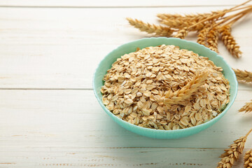 Oatmeal in bowl on white background. Healthy eating concept. Space for text