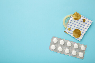 Contraceptive pills and condoms on blue background. Concept of birth control