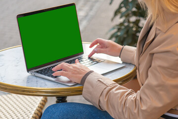 young woman businesswoman sits in a cafe behind a laptop. Business, work online
