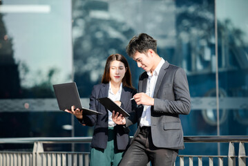 Kind leader executive manager share and discuss business solutions plan ideas on tablet with Asian female marketing manager in modern office..