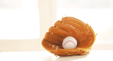 Baseball ball in a glove on the table.