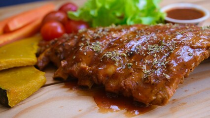 Top view grilled and smoked pork ribs with barbeque sauce on a carving board.