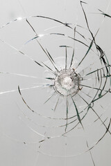 Glass breaks under impact: bullet hole and cracks