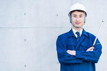 打診棒を持つ作業着を着た日本人男性